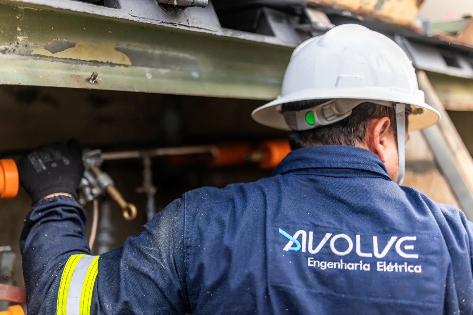 Eletricista da Avolve, de uniforme e capacete, em serviço na subestação